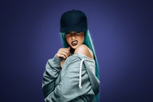 Sexy hip hop woman in hoodie and cap